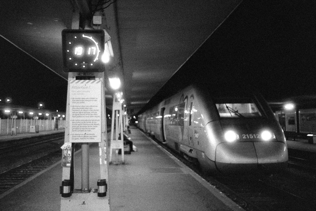 A black and white photograph of platform of the Orleans train station at night